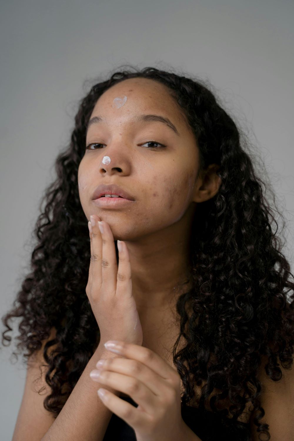 femme se mettant de la crème sur le visage